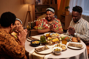 Happy Black family enjoying traditional Kwanzaa dinner at home