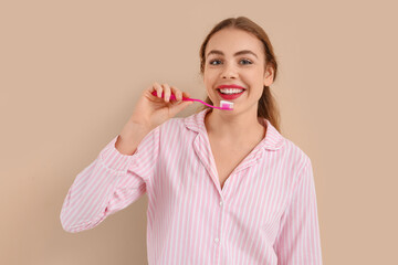 Sticker - Beautiful young woman brushing teeth on beige background