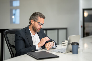 Office workplace. Handsome business man working with laptop at desk in office. Businessman typing on keyboard, online business meeting. Businessman working in office. Office worker using laptop.