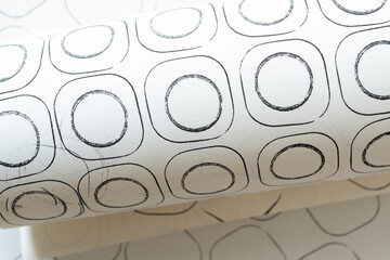 Sticker - close-up of rolled paper with abstract sketchbook paper featuring black ink circles in rounded corner squares