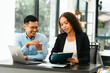 © NanSan - Asian business man and African American woman engaging in business discussion, possibly about merger or joint venture. two companies become one, one of companies often survives while other disappears