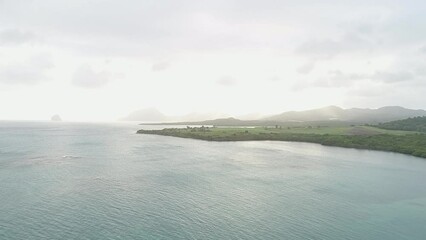 Poster - Drone shot over a sea with silhouette of hills in the distance at sunset