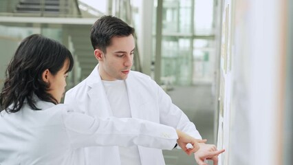 Poster - Multinational group in white coats having a conversation in a research facility.