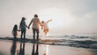 © Garun Studios - Happy Asian family jumping together on the beach on vacation.