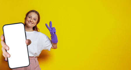 attractive woman in cleaning gloves holding smartphone with empty white screen display for new appli