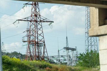 High voltage towers with sky background. Power line support with wires for electricity transmission. High voltage grid tower with wire cable at distribution station. Energy industry, energy saving