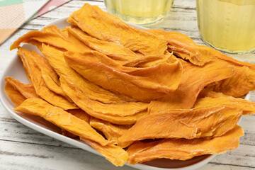 Wall Mural - Bowl with dried mango chips without added sugar close up for a snack