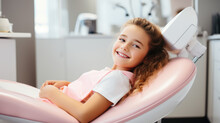 Сute Smiling Child Girl Sits In A Modern Dentist Chair Of Kids Dentistry Clinic. Dentist For Children, Modern Dental Clinic.