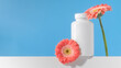 Mockup is a white jar with pills or vitamins on a podium. Vitamins for women. Copy space