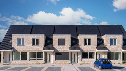 Newly built houses with solar panels attached on the roof against a sunny sky, Close up of new building with black solar panels. Zonnepanelen, Zonne energie, Translation: Solar panel, Sun Energy