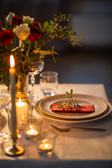 Wall Mural - holidays, dinner party and celebration concept - close up of festive table serving with flowers in vase and candles burning at home on valentine's day