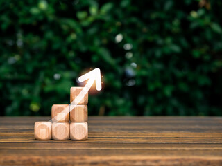 Poster - rising up glowing arrow on empty wooden cube blocks as a business graph or chart steps on table and 