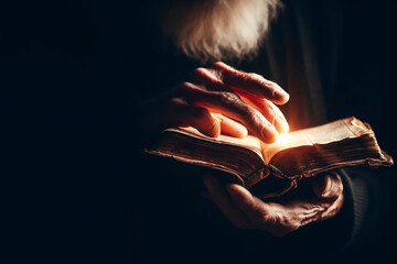 Old book bible in the hands of an old man closeup on dark background with point light on it. ai generative