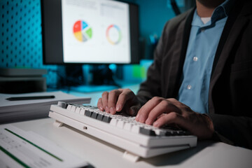 Poster - sitting and working in the office, Employee is looking for information on laptop, Recording various information on paper,