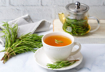 Wall Mural - Cup of healthy rosemary tea with fresh rosemary bunch on rustic background, winter herbal hot drink concept, salvia rosmarinus