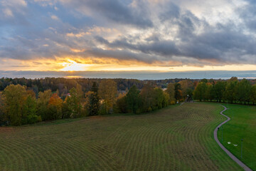 Wall Mural - autumn view from the observation tower of birch trees, mown grass and sunset, path on the right