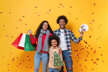  Happy African American family in festive Christmas celebration studio shot yellow color background with confetti