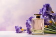 © Neira - Pink glass elegant perfume bottle mockup on mauve background with purple iris flowers. Glamour advertisement banner, copy space.