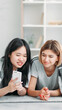 © golubovy - Device leisure. Technology youth. Two friends girls enjoying smartphone gadget internet social media content fun resting in light interior on floor at home.