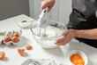 A female hands beat egg whites with a mixer