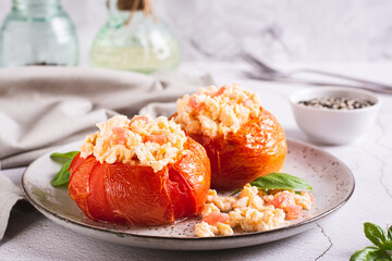 Canvas Print - Baked tomato halves filled with scrambled egg and basil on a plate on the table