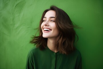 Wall Mural - Beautiful happy woman on green background looking to the side