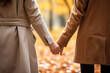 Couple holding hands in autumn, expressing affection and happiness. closeup