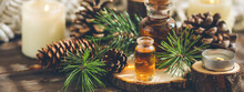 Christmas Home Aromatherapy. Aroma Diffuser With Pine Extract, Organic Essential Oil, Cedar And Spruce Cone, Candles On Wooden Table. Cozy Atmosphere Holiday Spirit. Winter Inspiration And Mood Banner