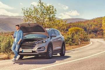 Man with a car problem waiting on an open road