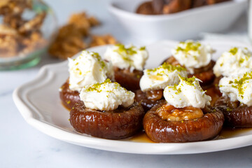 Wall Mural - Stuffed dry fig dessert, cooked with syrup, traditional, pistachio and kaymak (Turkish name; kaymakli incir tatlisi )