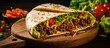 Flour tortilla filled with minced meat, veggies, lettuce, tomato, corn, bell pepper, beans, on a wooden board. (Selective focus on tortillas)