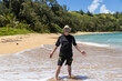 © Mat Hayward - Happy man wearing a floppy hat, sunglasses and a sun shirt for protection from UV rays having fun on a tropical island, beach for summer vacation.