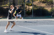 © Mat Hayward - Two adult men playing an intense game of tennis together on an outdoor court. The sport is fast and they are training during practice.
