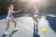 © Mat Hayward - Two female tennis players on court playing together as a team in a doubles match.