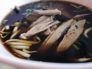 Noodles with the meat of duck, with green vegetables and bean sprouts as elements.