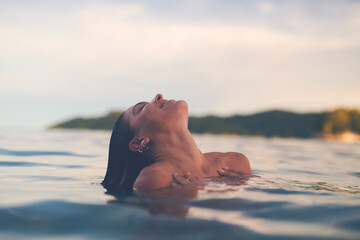 Canvas Print - Ocean, swimming and woman with vacation, travel and relax with getaway trip, freedom and outdoor for fun. Person, tourism and girl with holiday, water and summer with weekend break, carefree or smile