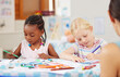 © Nina L/peopleimages.com - Children, pencil and drawing for homework in classroom with creative, art or project for picture. Little girl, friend and diversity with serious look for learning, education and decision for coloring