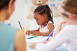 © Nina L/peopleimages.com - African, kid and pencil for drawing in classroom for learning, education and development of motor skills. Little girl, student on learner with serious, determination and look for creative activity