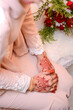 Henna Tattoo on Bride's Hand. Malay wedding preparation henna party. Temperate white mehndi.