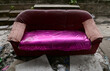 Closeup of Dirty Old Colorful Sofa left in the forest on the side of the road at Thailand. Selective Focus.
