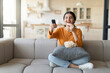 © Prostock-studio - Happy Young Indian Woman Holding Remote Controller And Eating Popcorn At Home