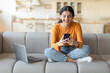 © Prostock-studio - Young Smiling Indian Woman Using Smartphone And Laptop At Home