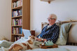 © Westend61 - Senior man using laptop near dog on bed at home