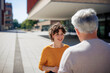 © Westend61 - Smiling woman talking to senior man on sunny day