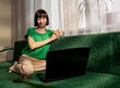 © Westend61 - Smiling freelancer holding cup of tea and talking on video call through laptop at home