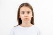© puhimec - Teenage girl looks at the camera in surprise on a white background isolated.