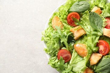 Wall Mural - Delicious salad with chicken, cherry tomato and spinach on light grey table, top view. Space for text