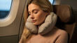 © AstraNova - Beautiful Female traveler sleep and relax comfortably by wrapping a pillow around your neck while traveling in an airplane cabin