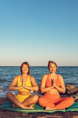 Sticker - Yoga instructor with a student practice yoga on the beach