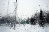 Fototapeta Łazienka - View on winter town through wet windshield with rain drops.
